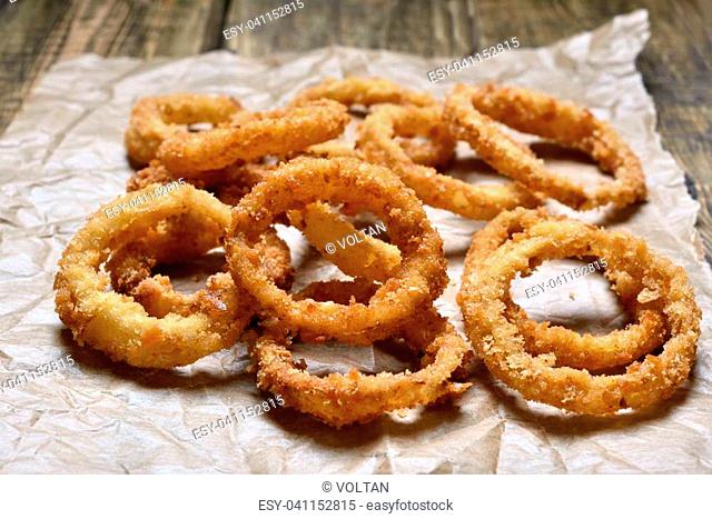 Onion rings on paper, close up view