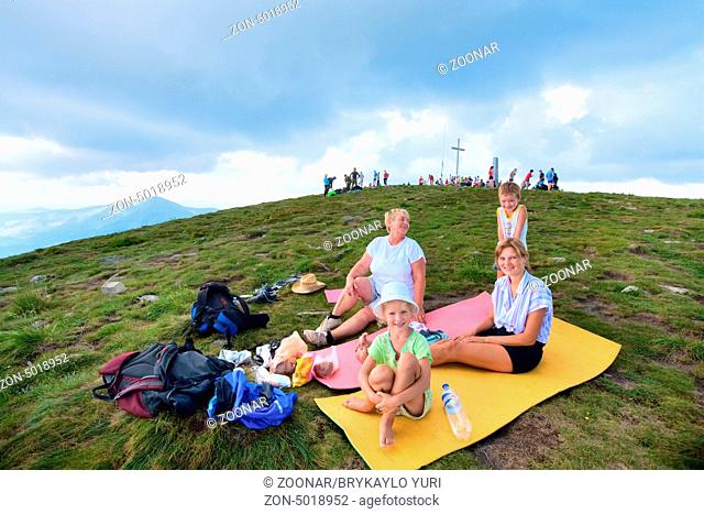 Family resting on summer mountain top (Goverla Mount, Carpathian, Ukraine)