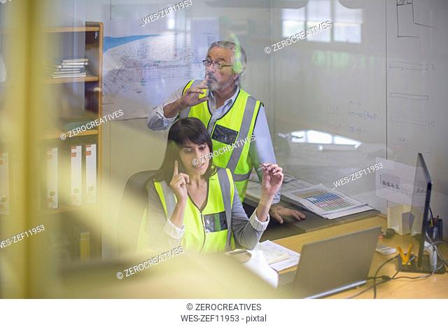 Female construction engineer making a call in site office