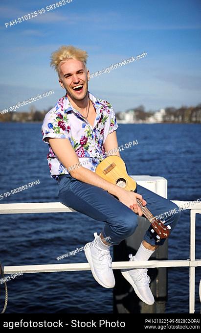 24 February 2021, Hamburg: Jendrik Sigwart, singer and musical performer, sits on a railing during a photo session at the Alster
