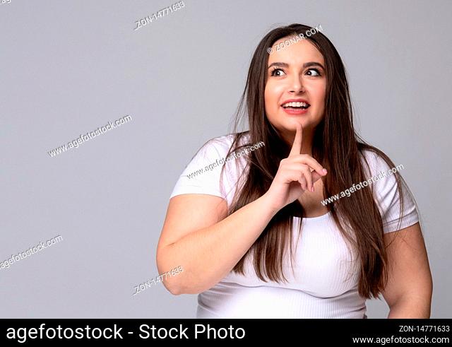 Plus Size Girl holds finger at mouth urging to keep silence