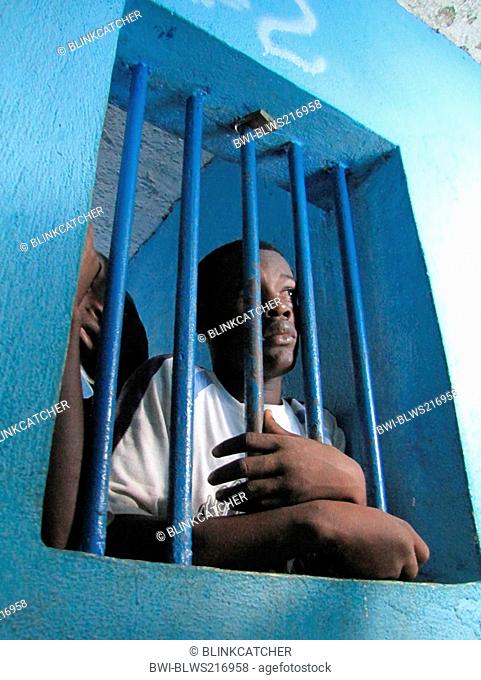 detainees behind bars of a window in run-down predetention cell garde à vue at police station, commissariat of Jérémie, Haiti, Grande Anse, Jeremie