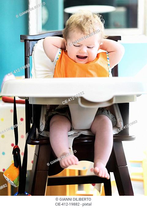 Baby girl crying in high chair