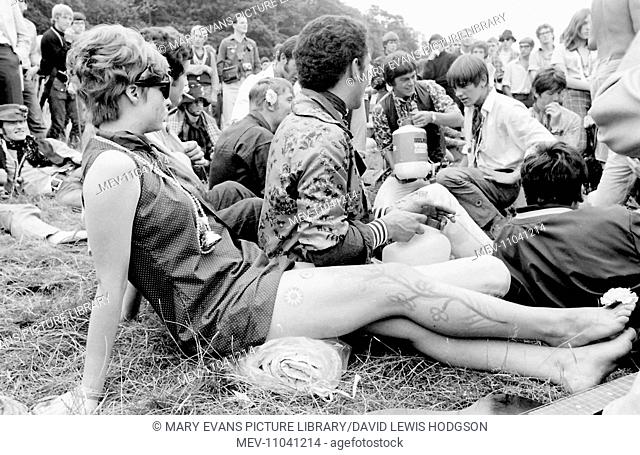 A group of hippy men and women relaxing in a field at a Love-In at Woburn Park, Bedfordshire