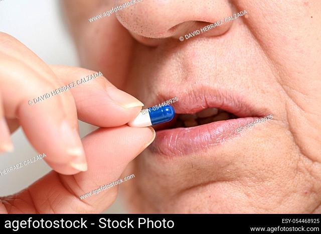 Close up of a senior woman swallowing pill