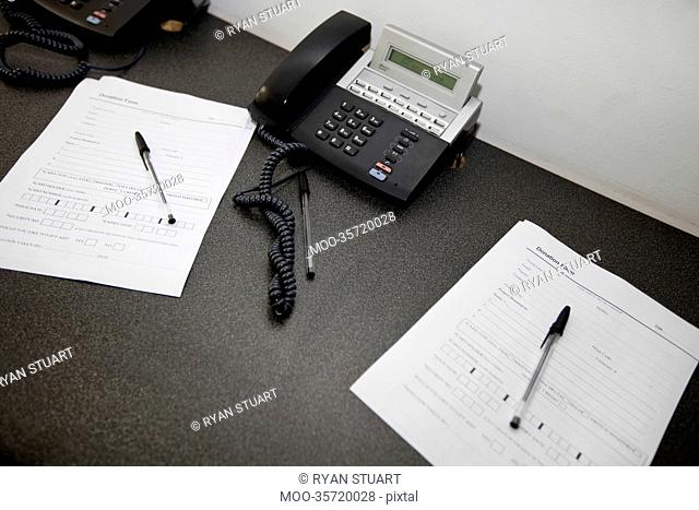 Documents and landline telephones on table