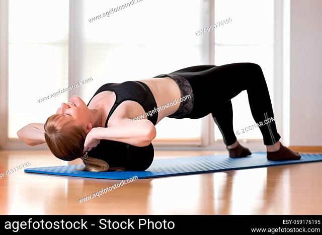 Young girl doing sport excercise with fascia roll