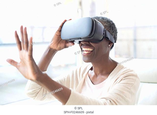 Mature woman wearing virtual reality headset and waving
