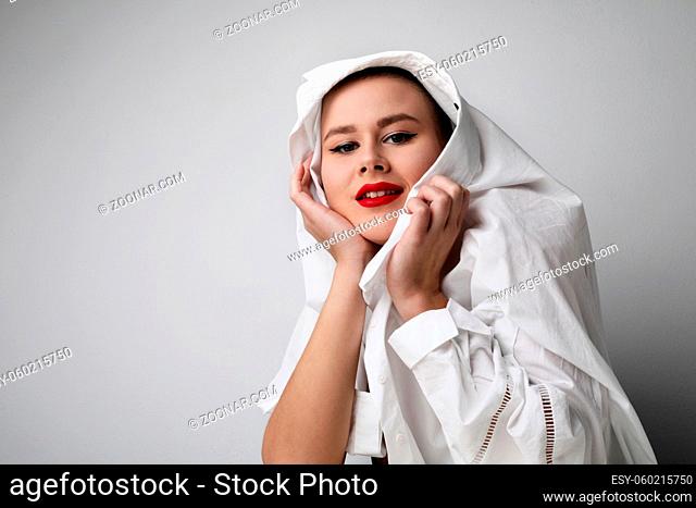Close-up portrait of bald pretty woman with red lips, posing on white wall. Isolated. High quality photo