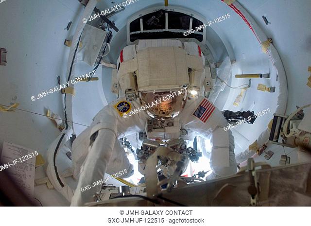 Astronaut Steve Swanson, STS-119 mission specialist, attired in his Extravehicular Mobility Unit (EMU) spacesuit, exits the Quest Airlock of the International...