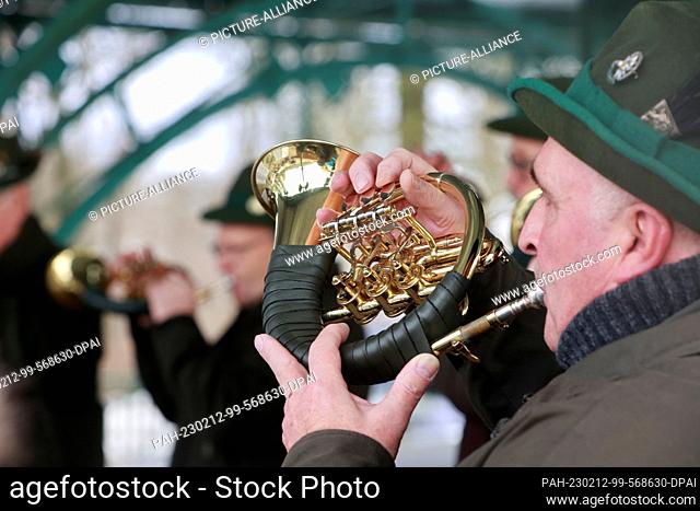 12 February 2023, Saxony-Anhalt, Stolberg: Hunting horn players play for the opening of the Winterfest in front of the Josephskreuz on the Auerberg