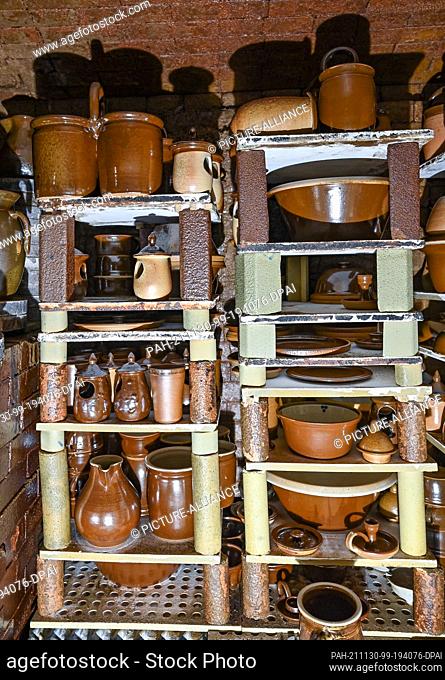 26 November 2021, Brandenburg, Groß Neuendorf: Ready-fired jugs, bowls, cups and other products stand in the kiln of potter Dannegger after firing