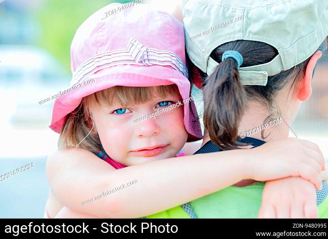 sad crying little girl hugging her mother