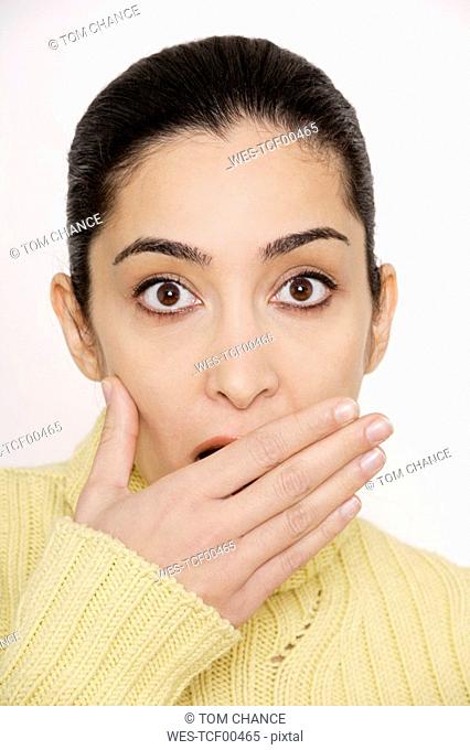 Young woman covering mouth with hand