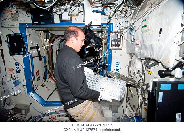 In the International Space Station's Destiny laboratory, NASA astronaut Rick Mastracchio, Expedition 38 flight engineer, prepares to replace a dewar tray in the...