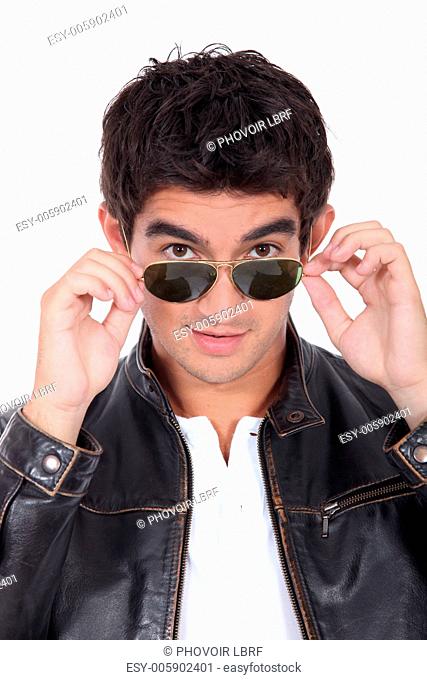 Young man wearing leather jacket and trendy sunglasses