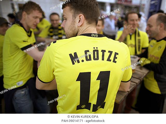 A fan of Borussia Dortmund wearing a jersey with the inscription 'M. Goetze' stands in downtown Dortmund, Germany, 24 April 2013