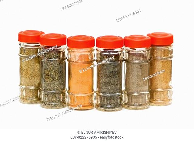 Various spices in bottles isolated on white