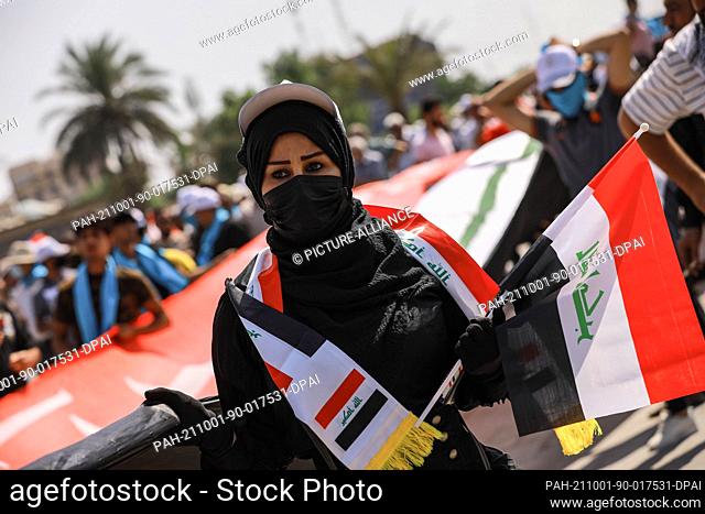 01 October 2021, Iraq, Baghdad: An Iraqi woman takes part in an anti-government march from Firdos Square to Tahrir Square