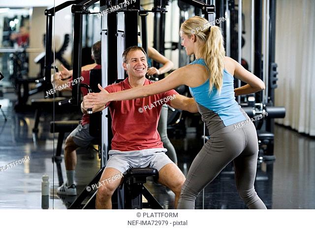 A man and a woman weight training at a gym Sweden