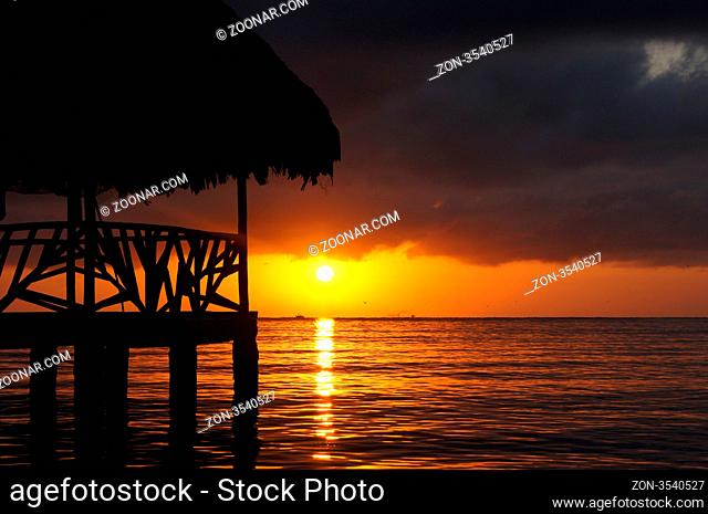 Sunset, cloud and hut on the sea shore in Carribean coast of Guatemala