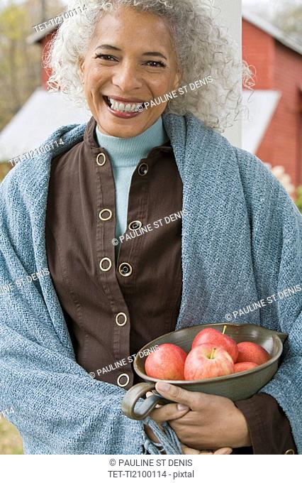 Woman holding bowl of apples
