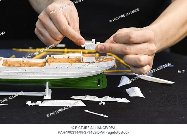 12 March 2019, Berlin: A woman assembles parts of a model of the sailing training ship Gorch Fock. (to dpa-Story ""The ""Gorch Fock""-Desaster: Fall in the dry...