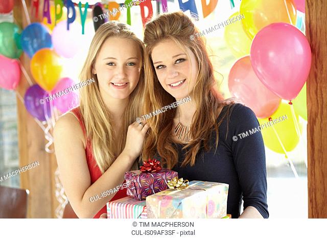 Two teenage girls sharing gifts at birthday party