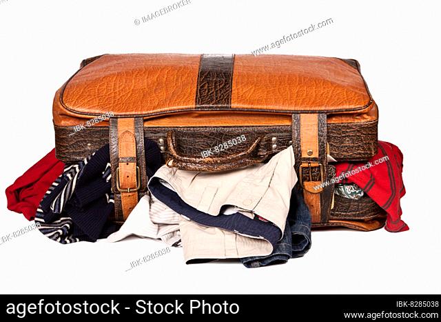 Overstuffed baggage in old suitcase isolated on white background
