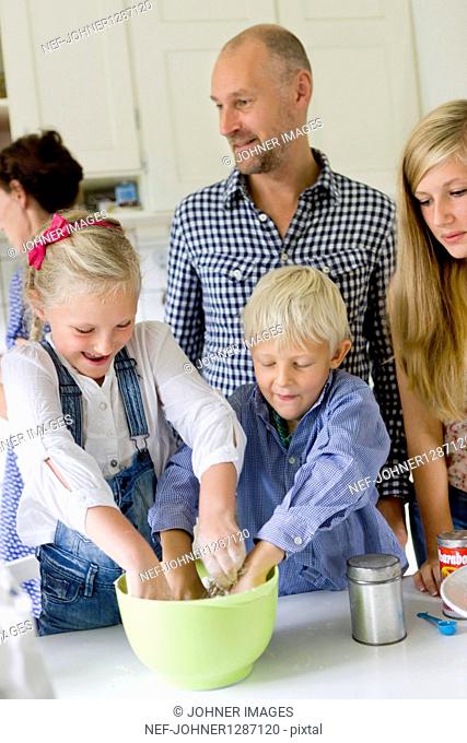 Family preparing food in kitchen