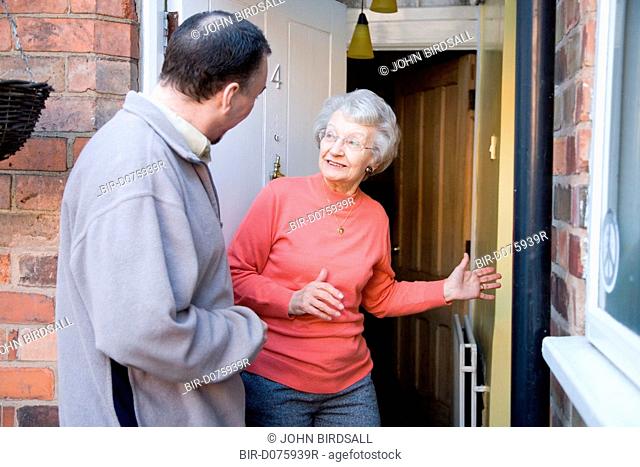 Older woman greeting an IndependentAge volunteer at her front door