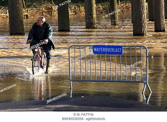 cyclists on flooded road, Belgium, Durme