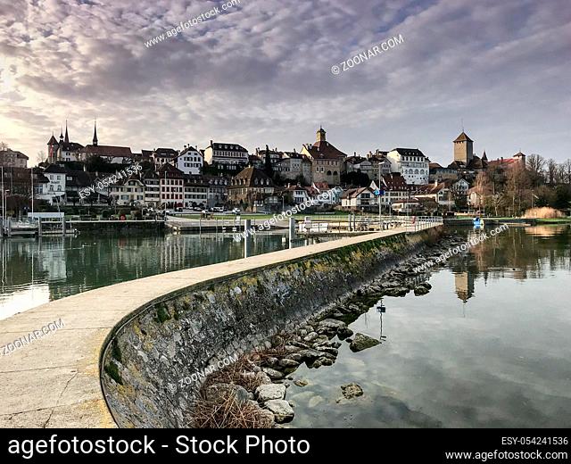gorgeous view of pier and lake and the picturesque Swiss city of Murten in the early evening