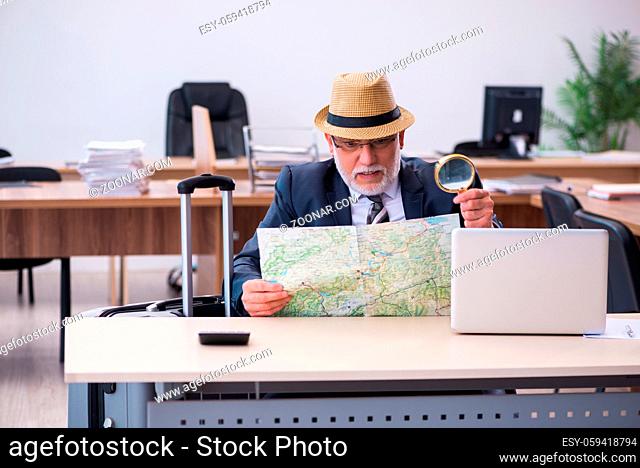 Aged male employee preparing for travel in the office