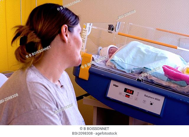 Photo essay from hospital. Mother-child center. Hospital of Meaux 77, France. 2-day-old newborn baby girl in a heated bed with her mother