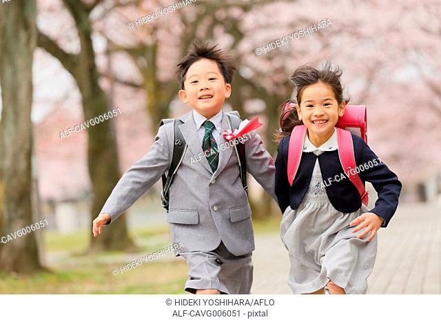 Japanese kids with cherry blossoms in a city park