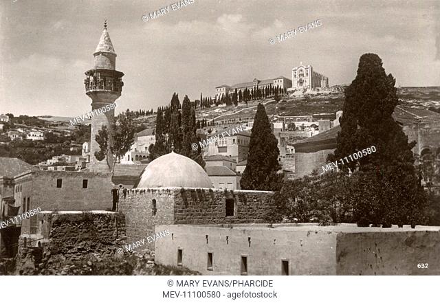 Mosque in the foreground with the Salesian Church of Jesus the Adolescent (established 1923), Nazareth, Northern Israel on the hill above