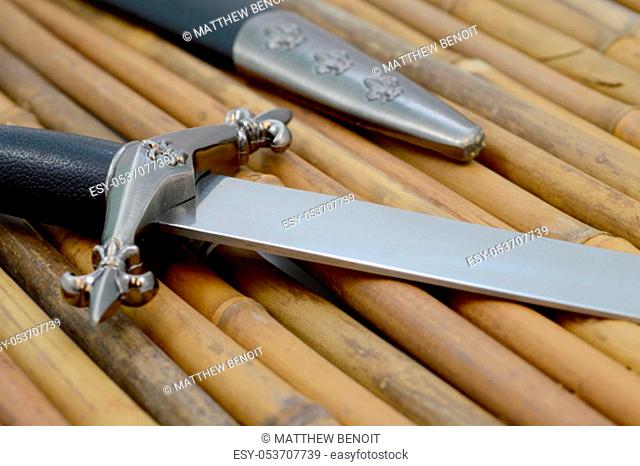 Closeup view of a fine craftsman dagger and sheath with focus on the blade