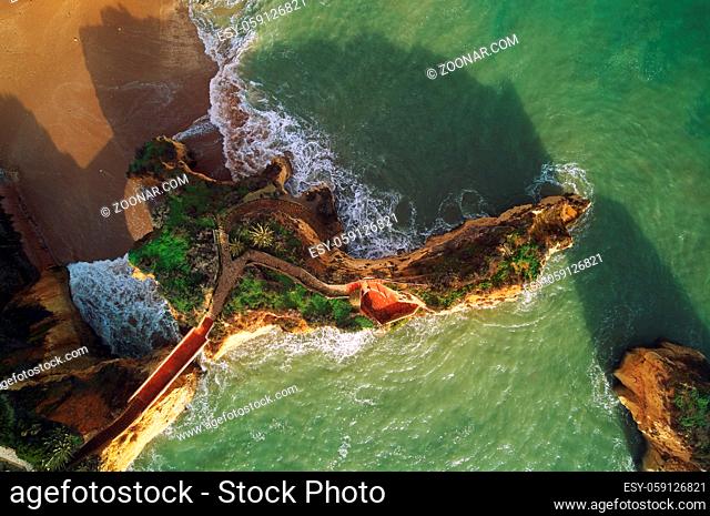 Aerial photo directly from above view Ponta da Piedade headland with group of rock formations yellow-golden cliffs along limestone coastline, Lagos town