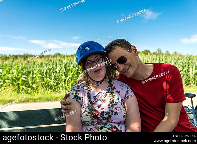 Young caucasian woman with Down Syndrome smiling and embracing her white brother, Tienen, Belgium