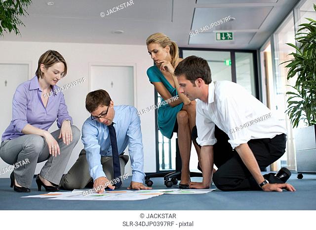 Businesspeople examining work in office