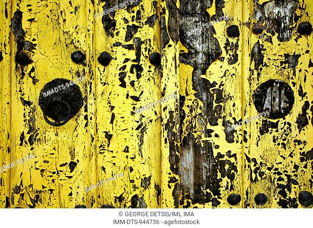 Metal door handle on yellow painted wood. Monodendri, Zagorohoria, Ioannina, Greece, Europe