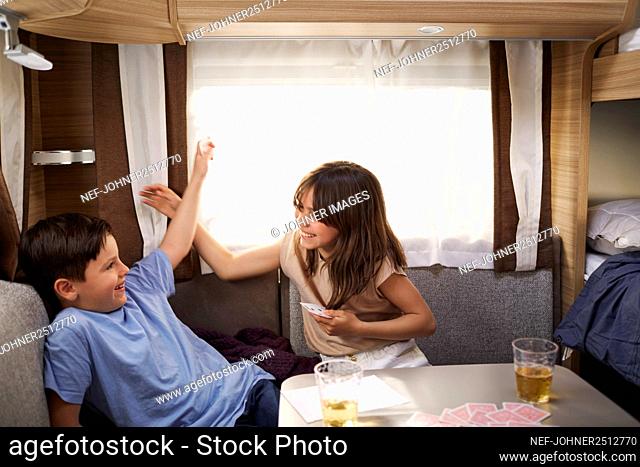 Children playing cards in camper van