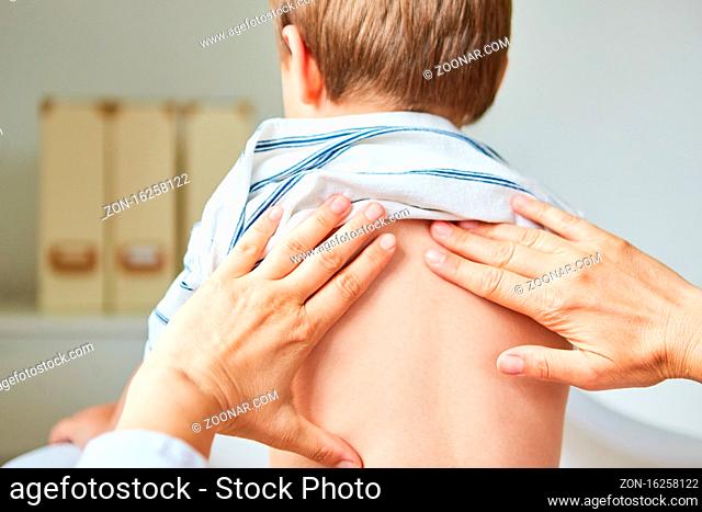 Heilpraktiker oder Physiotherapeut berührt Rücken von Kind mit Händen bei Reiki