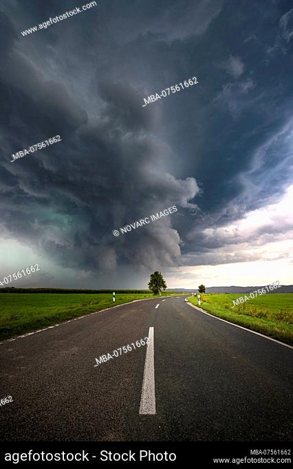 Shimmering green precipitation core of a supercell with street in the foreground near Altdorf near Nuremberg, Bavaria, Germany