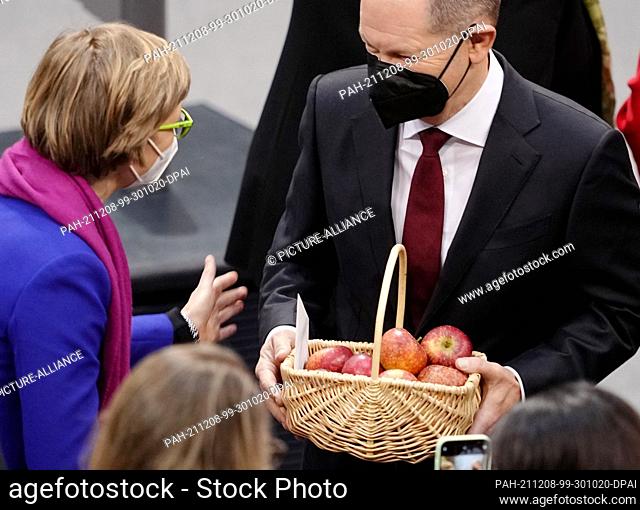 08 December 2021, Berlin: Members of parliament congratulate Olaf Scholz (r , SPD) after his election as Federal Chancellor, holding a basket of apples