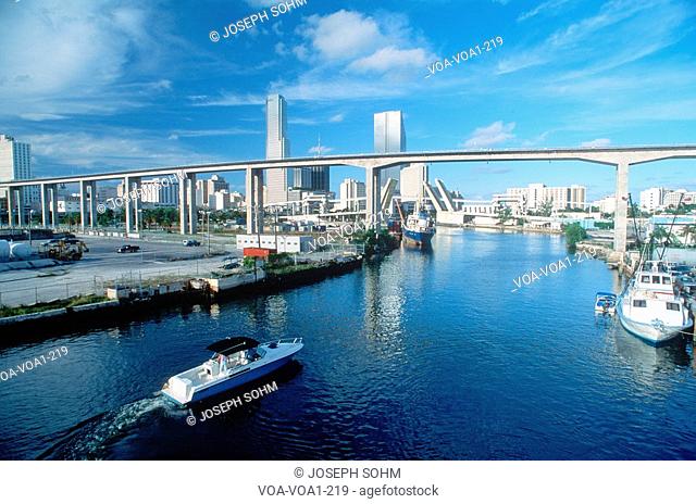 Waterway underneath metro rail line with skyline in background in Miami, Florida