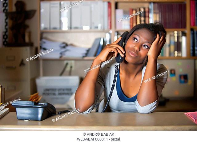 USA, Texas, Young woman having conversation in office