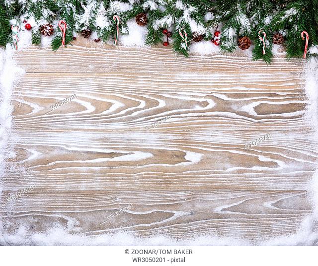 Rustic white wooden boards with snowy fir branches for Christmas season concept