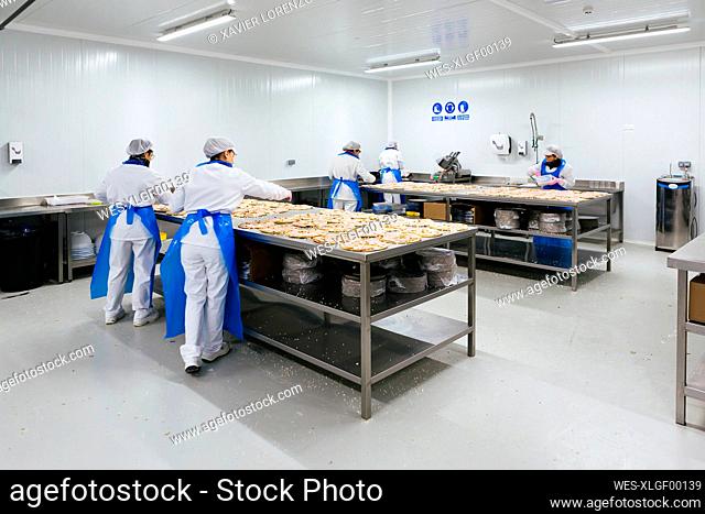 Women preparing pizzas in pizza company
